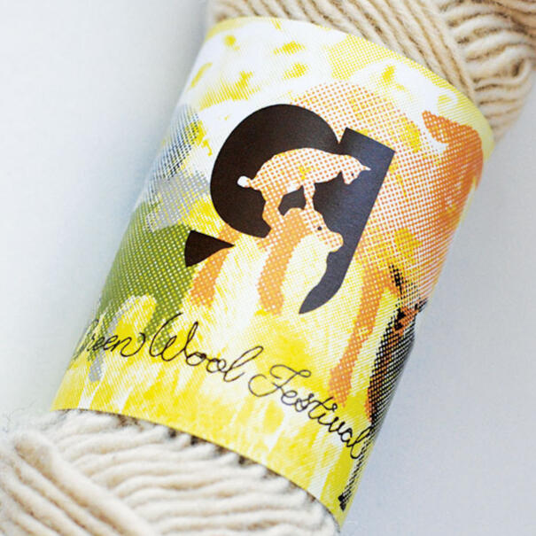 yarn with label with logo of "g" with lamb standing on sheep's head and "Green Wool Festival" with background sheep