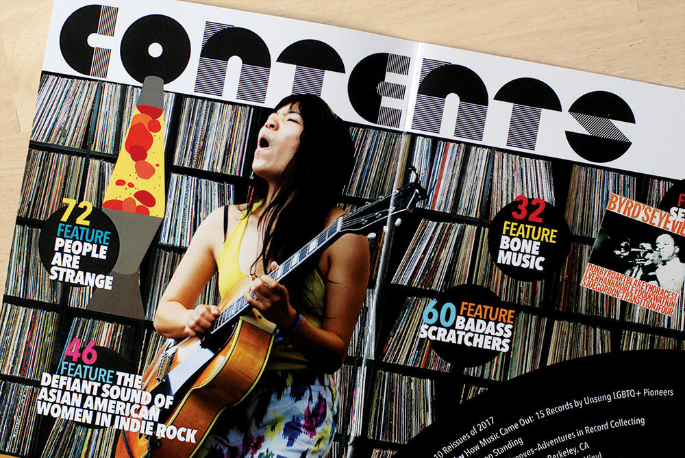 magazine spread: Contents with images on top of wall of vinyl on shelves background
