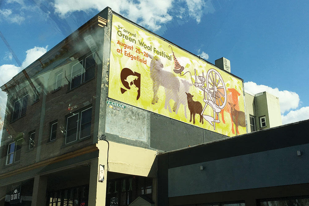 mockup of billboard on side of building: Green Wool Festival August 25–26 at Edgefield with sheep and spinning wheel