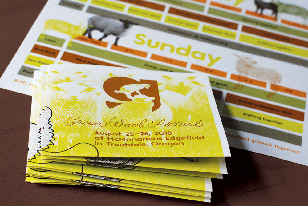 stack of square folded flyers with g logo and "Green Wool Festival" and info with calendar in background